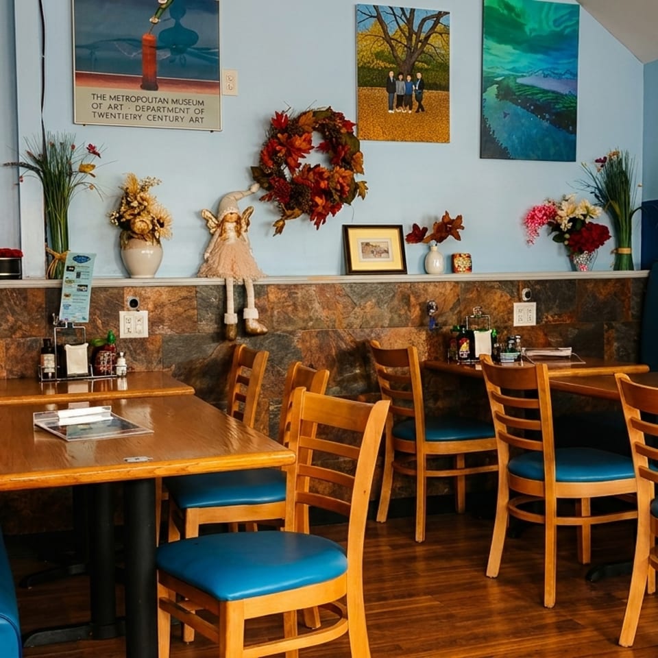 Cozy restaurant interior with blue booths, wooden tables, and decorative wall art.